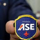 A technician holding an ASE certification patch.